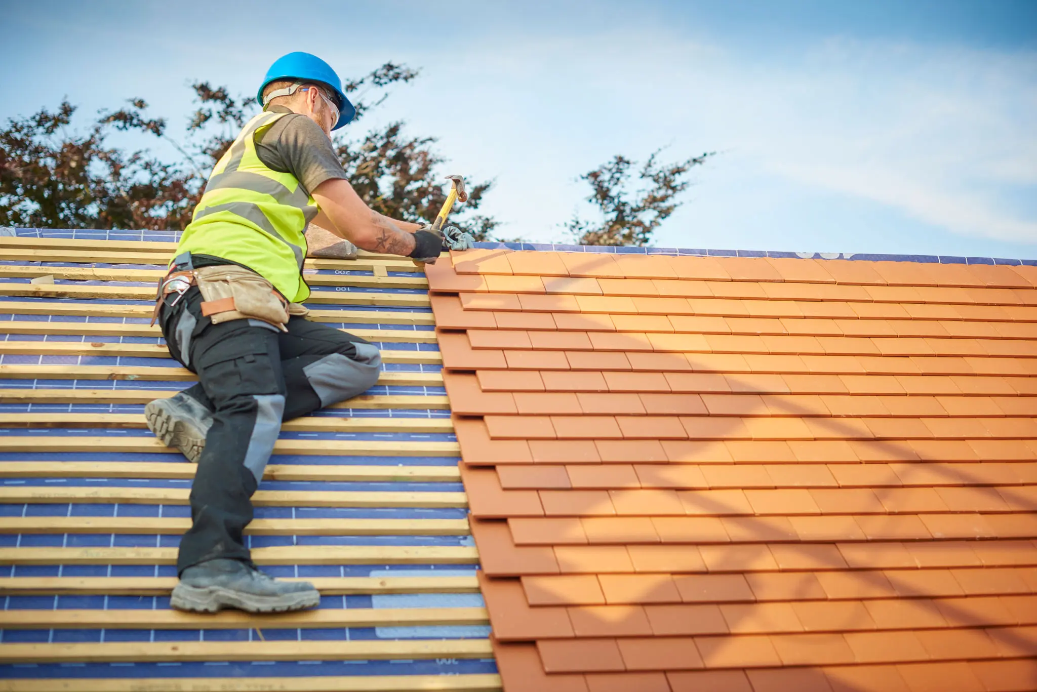 Roofer installing shingles on a roof.